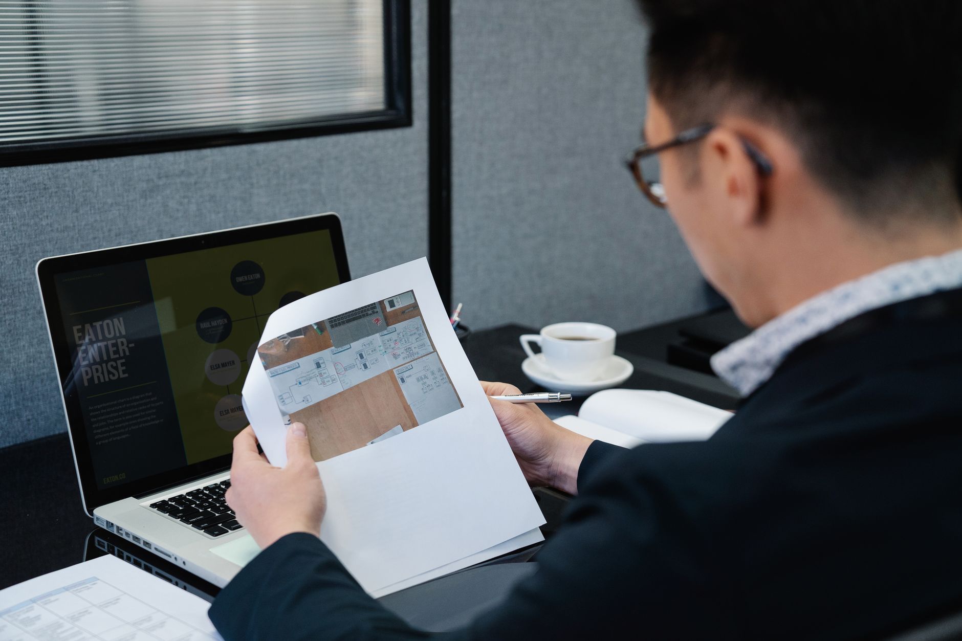 A man in an office setting analyzing documents with a laptop open nearby — illustrating: MSP Tools Comparison: Remote Monitoring, Ticketing & Automation Ranked for Central Florida Businesses